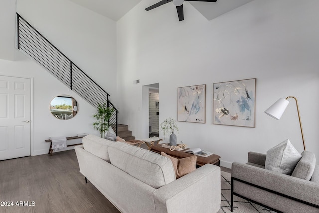 living room featuring ceiling fan, dark hardwood / wood-style flooring, and a high ceiling