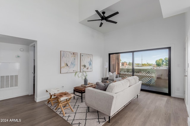 living room featuring hardwood / wood-style flooring, high vaulted ceiling, and ceiling fan