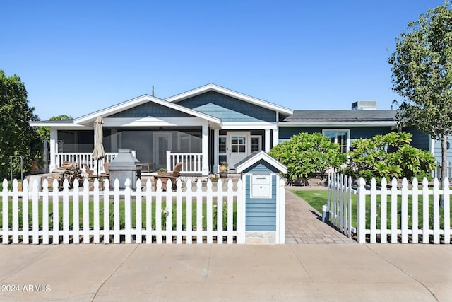 view of front facade with a sunroom and a front yard