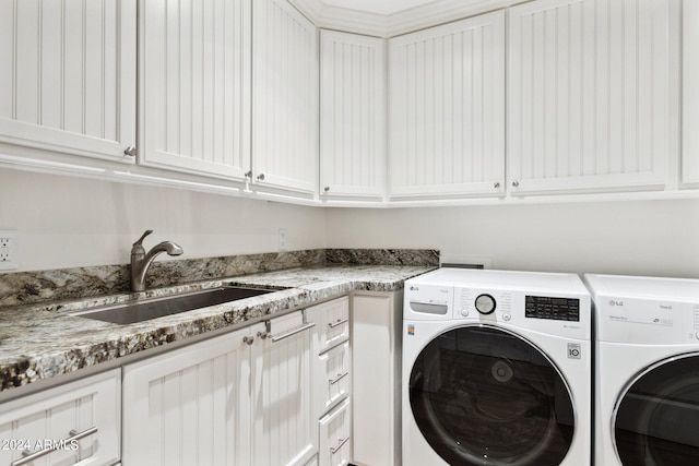 laundry area with cabinets, independent washer and dryer, and sink