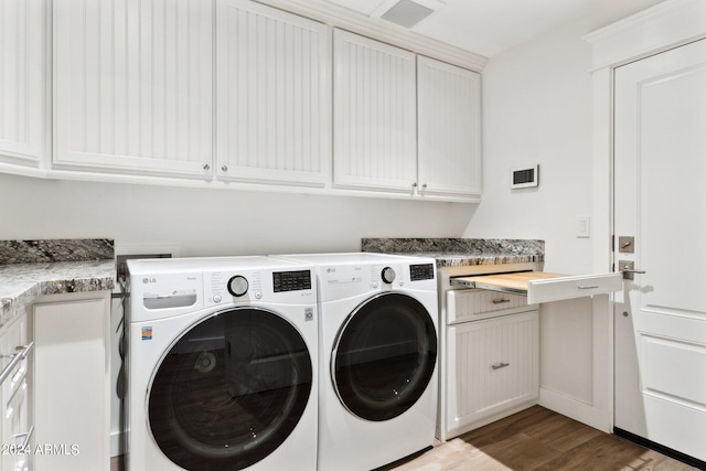 washroom with dark hardwood / wood-style flooring, independent washer and dryer, and cabinets