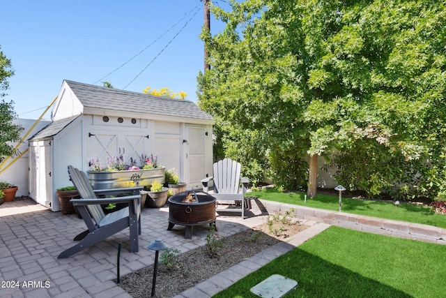 view of patio / terrace with a shed and an outdoor fire pit