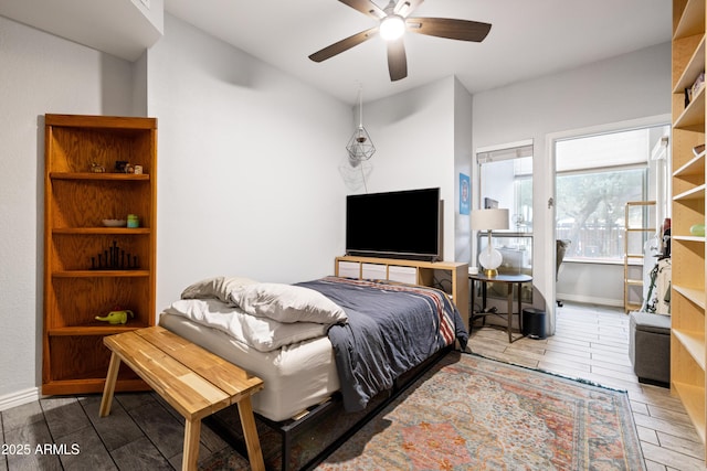 bedroom featuring a ceiling fan, baseboards, and wood finished floors