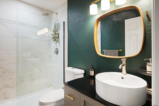 bathroom with a textured wall, a tile shower, and toilet