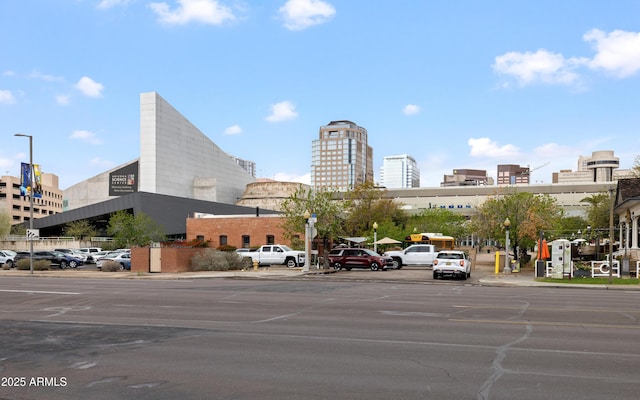 view of road featuring street lighting, a city view, curbs, and sidewalks