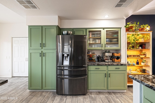 kitchen featuring wood tiled floor, visible vents, green cabinets, and stainless steel fridge with ice dispenser