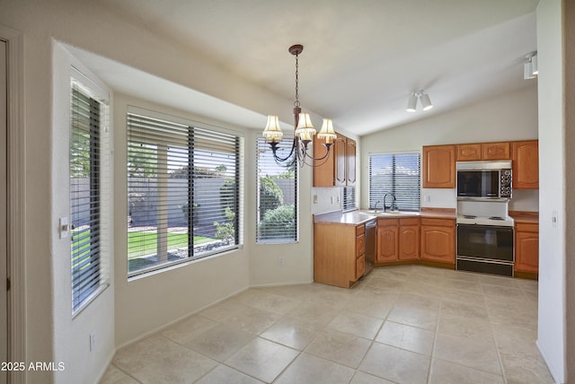 kitchen with decorative light fixtures, stainless steel appliances, light countertops, a sink, and a chandelier