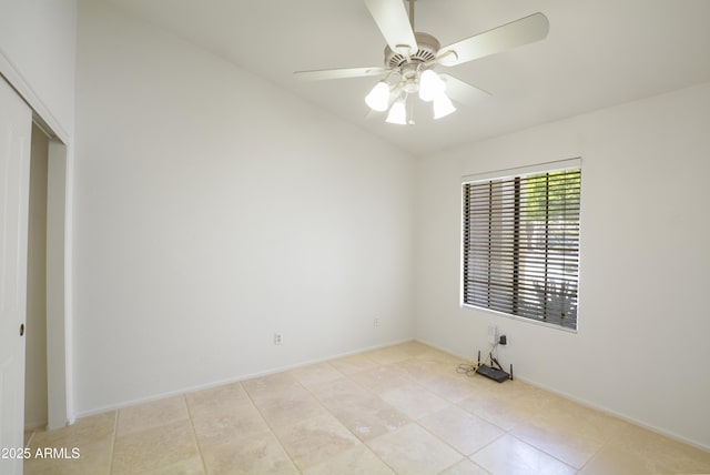 empty room with light tile patterned flooring, a ceiling fan, and baseboards