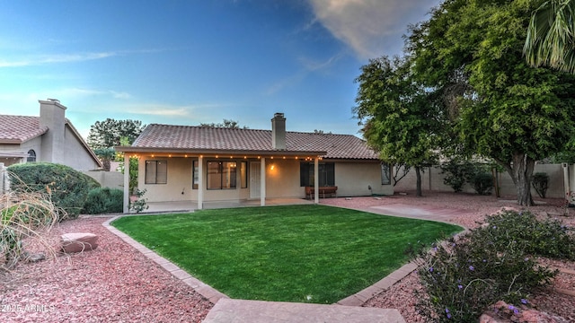 back of house featuring a tiled roof, a patio, and stucco siding