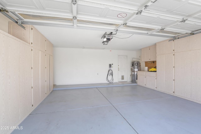 garage featuring a garage door opener and hybrid water heater