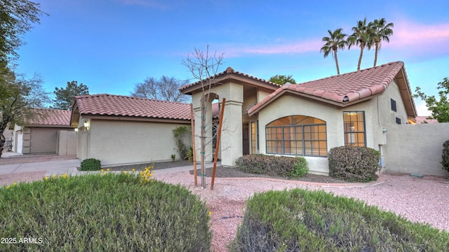 mediterranean / spanish-style home with a tiled roof and stucco siding