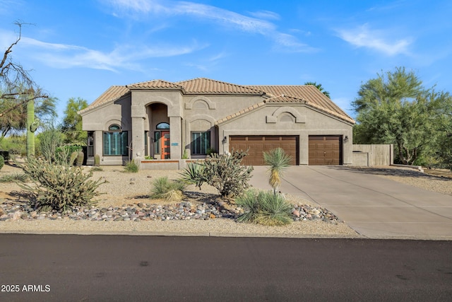 26475 N Wrangler Rd, Scottsdale, AZ 85255 - mediterranean / spanish-style house with a garage, a tiled roof, concrete driveway, and stucco siding