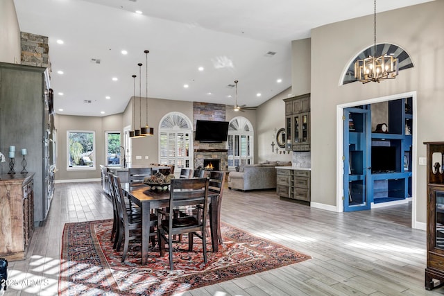 26475 N Wrangler Rd, Scottsdale, AZ 85255 - dining room with high vaulted ceiling, a chandelier, a fireplace, light wood finished floors, and recessed lighting