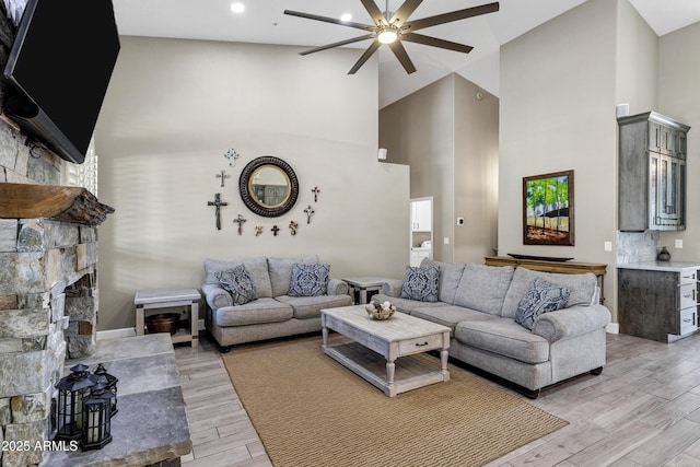 26475 N Wrangler Rd, Scottsdale, AZ 85255 - living area with a ceiling fan, light wood finished floors, high vaulted ceiling, a stone fireplace, and recessed lighting