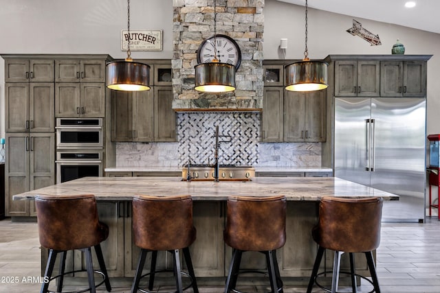 26475 N Wrangler Rd, Scottsdale, AZ 85255 - kitchen featuring appliances with stainless steel finishes, tasteful backsplash, a center island with sink, light stone countertops, and light wood-style floors