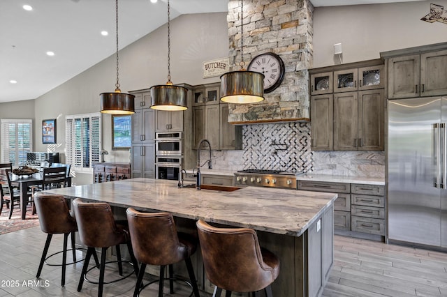 26475 N Wrangler Rd, Scottsdale, AZ 85255 - kitchen featuring appliances with stainless steel finishes, high vaulted ceiling, light wood-type flooring, tasteful backsplash, and light stone countertops