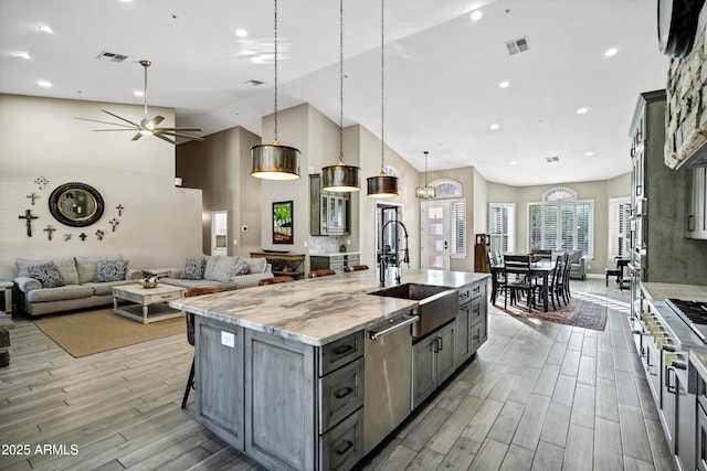26475 N Wrangler Rd, Scottsdale, AZ 85255 - kitchen with dishwasher, ceiling fan, light wood finished floors, an island with sink, and light stone counters