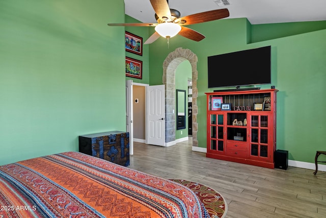 26475 N Wrangler Rd, Scottsdale, AZ 85255 - bedroom with wood finished floors, arched walkways, a high ceiling, and ceiling fan