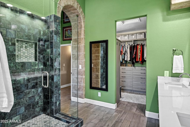 26475 N Wrangler Rd, Scottsdale, AZ 85255 - bathroom featuring a stall shower, wood finished floors, a spacious closet, and double vanity
