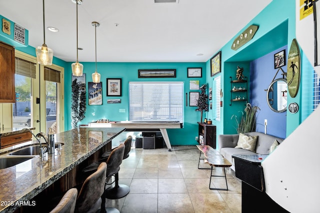 26475 N Wrangler Rd, Scottsdale, AZ 85255 - kitchen with a kitchen bar, pendant lighting, dark stone counters, light tile patterned floors, and recessed lighting