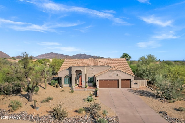 26475 N Wrangler Rd, Scottsdale, AZ 85255 - mediterranean / spanish home featuring an attached garage, a tile roof, concrete driveway, a mountain view, and stucco siding