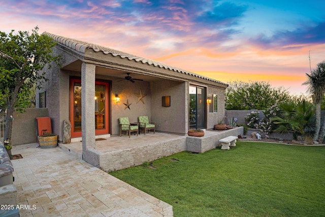 26475 N Wrangler Rd, Scottsdale, AZ 85255 - back of property with a ceiling fan, a lawn, a patio area, stucco siding, and a tile roof
