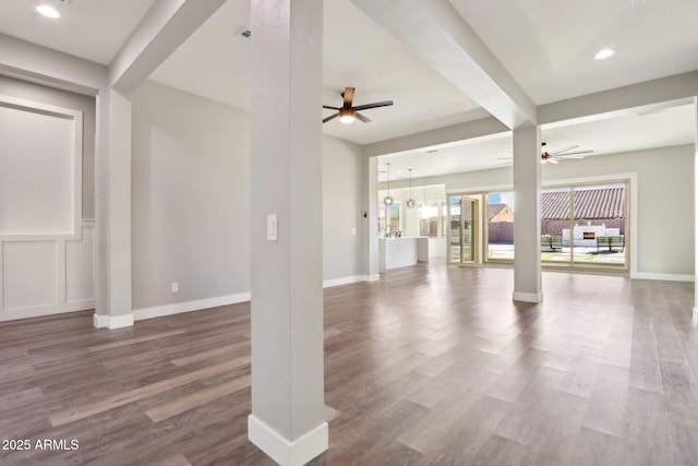 unfurnished living room featuring hardwood / wood-style flooring, ceiling fan, and beam ceiling