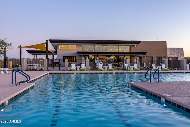 view of pool at dusk