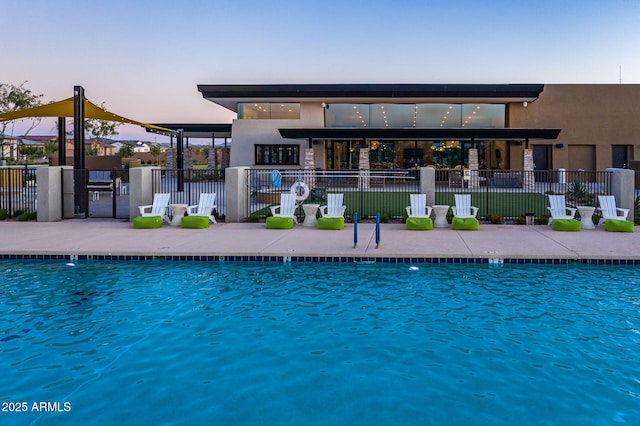 back house at dusk featuring a community pool