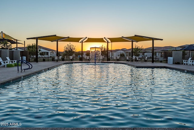 pool at dusk featuring central AC, a patio area, and pool water feature