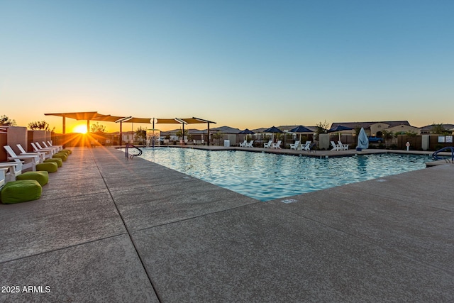 pool at dusk featuring a patio