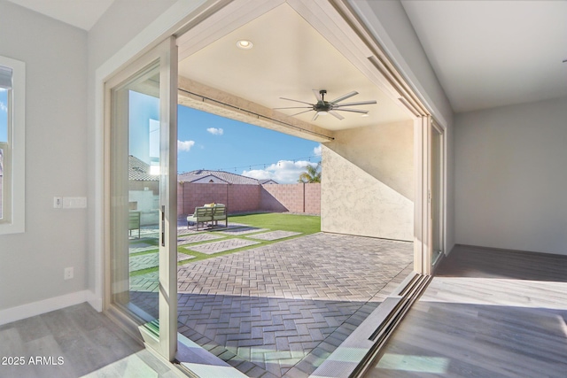 doorway with hardwood / wood-style flooring and ceiling fan