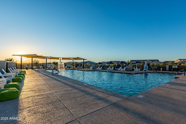 pool at dusk featuring a patio area