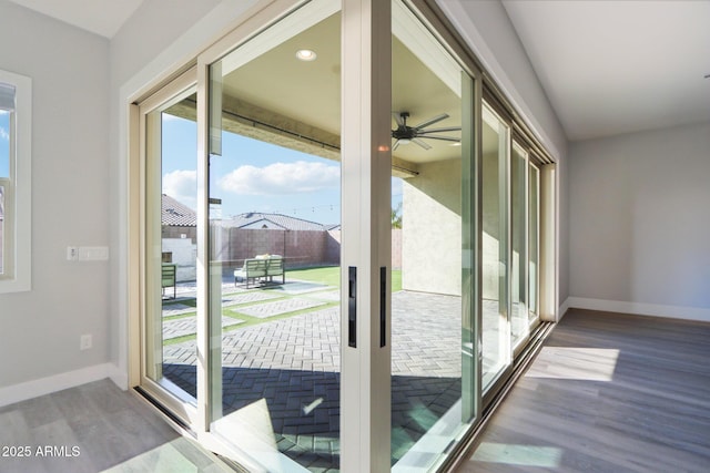 doorway with hardwood / wood-style flooring and ceiling fan