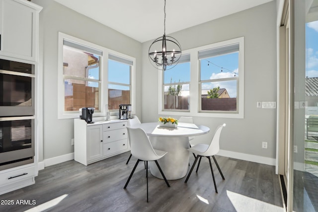 dining space featuring dark wood-type flooring and an inviting chandelier