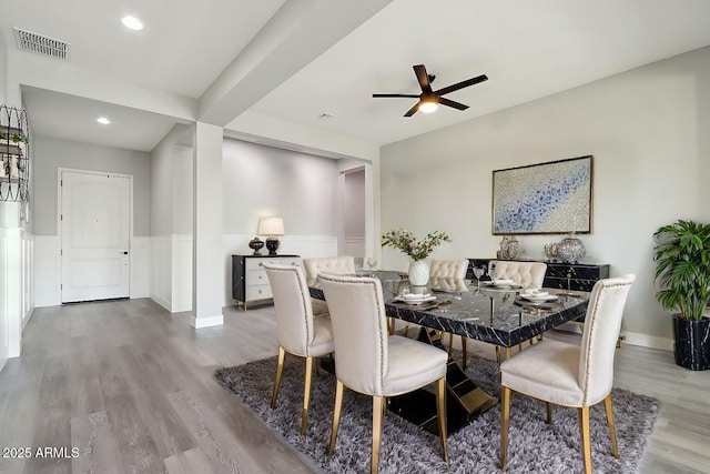 dining space with ceiling fan and light wood-type flooring