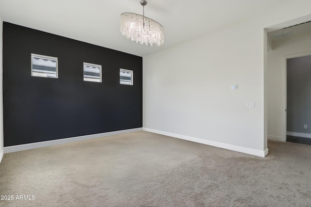 unfurnished room featuring carpet flooring and a notable chandelier