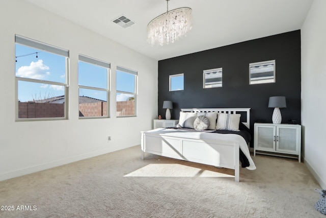 carpeted bedroom with a notable chandelier