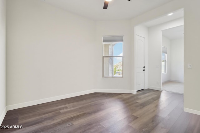 unfurnished room with ceiling fan and dark hardwood / wood-style flooring