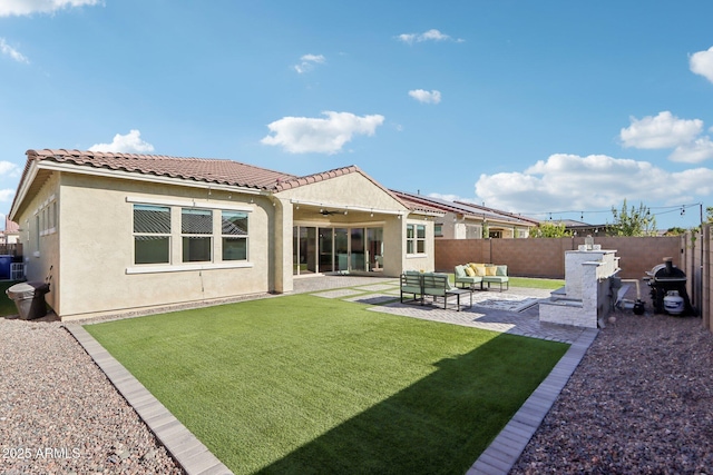 back of property with a yard, outdoor lounge area, and a patio