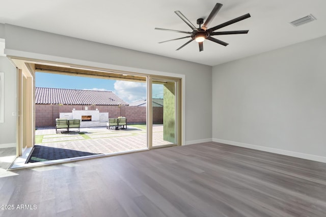 empty room with hardwood / wood-style floors and ceiling fan