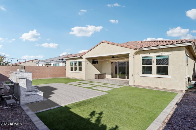 back of house with a yard, a patio, and ceiling fan