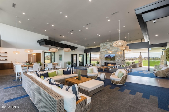 living room featuring a fireplace and a high ceiling