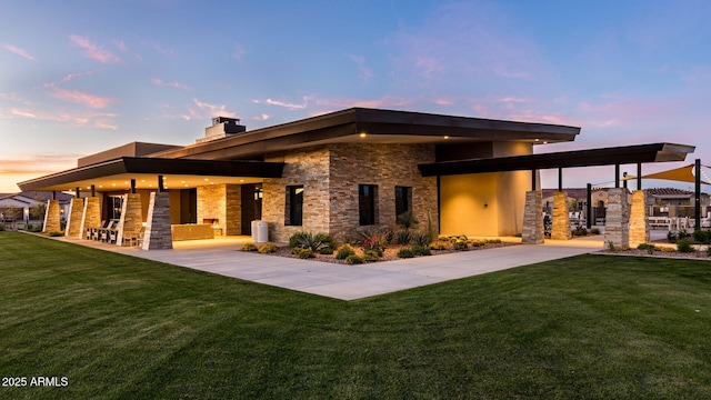 back house at dusk featuring a yard