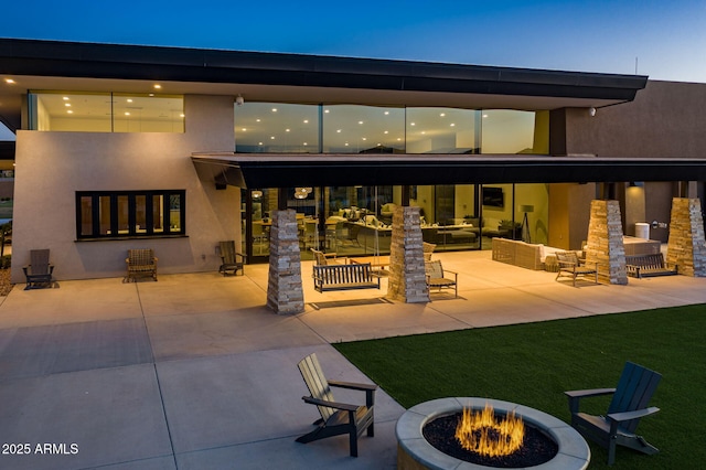 back of property with a patio area and an outdoor fire pit