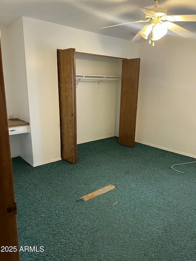 unfurnished bedroom featuring a ceiling fan, built in study area, carpet, a textured ceiling, and a closet