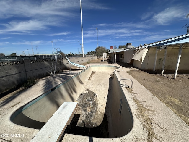 exterior space with a fenced in pool, a water slide, and fence