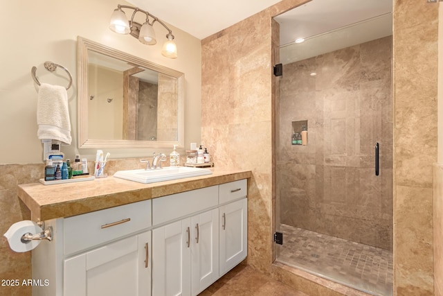 bathroom featuring a shower with shower door and vanity