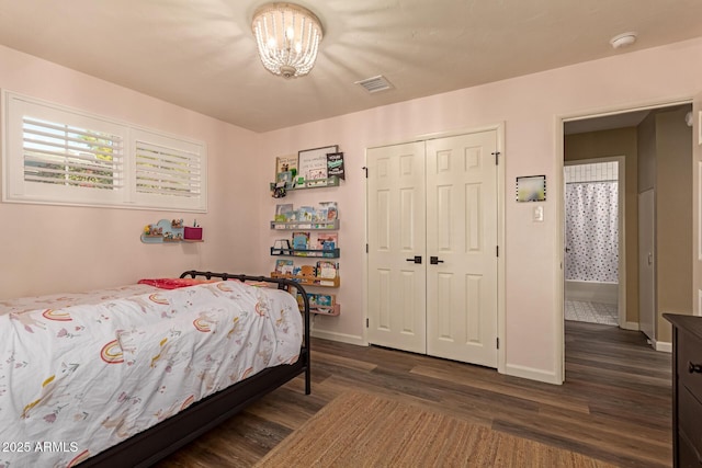 bedroom with a closet, a chandelier, and dark hardwood / wood-style floors