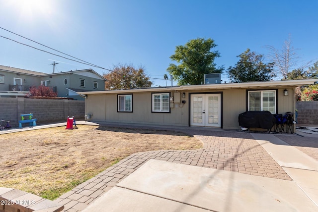 ranch-style home with central AC, french doors, and a patio